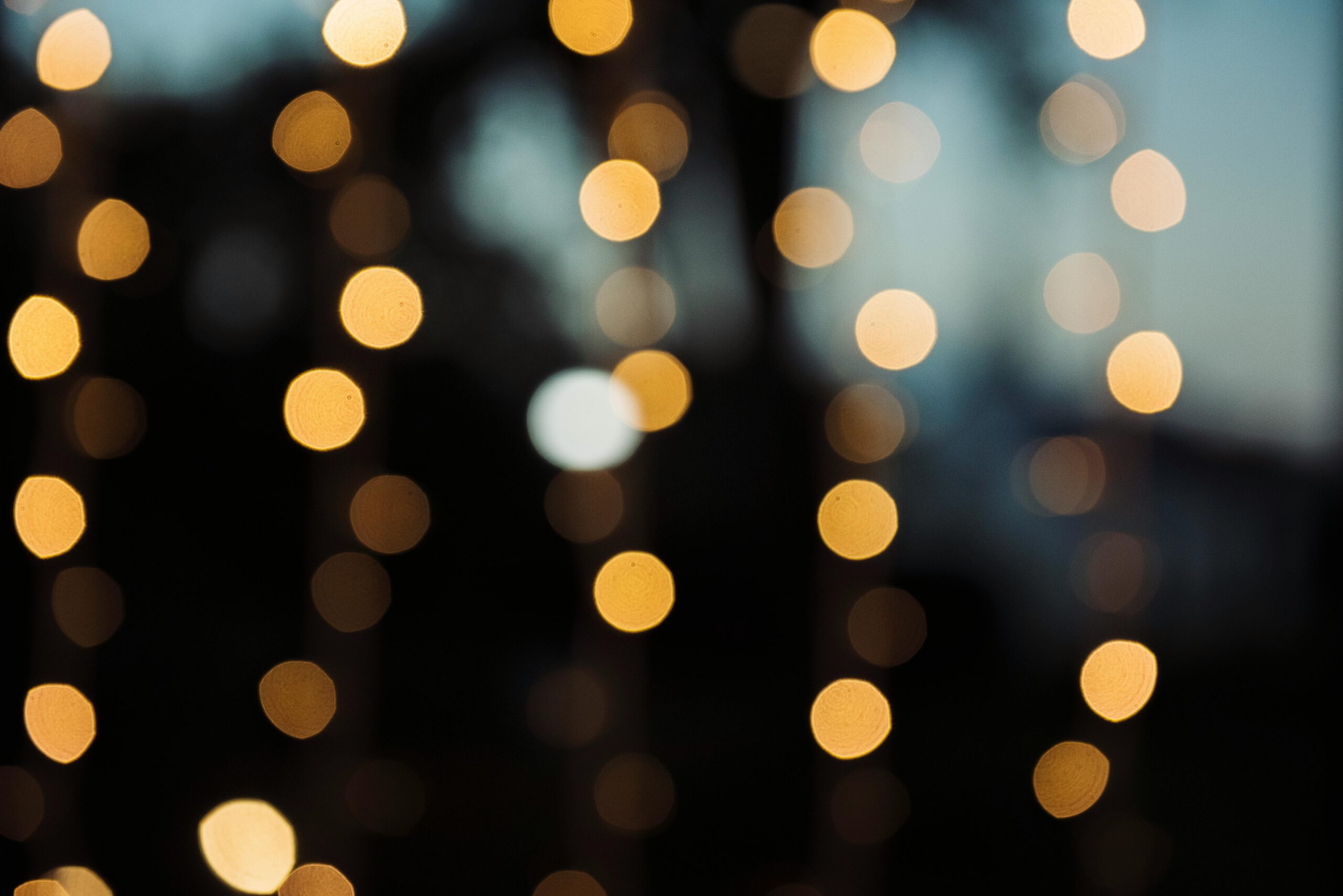 A warm and abstract defocused background with circular bokeh lights.